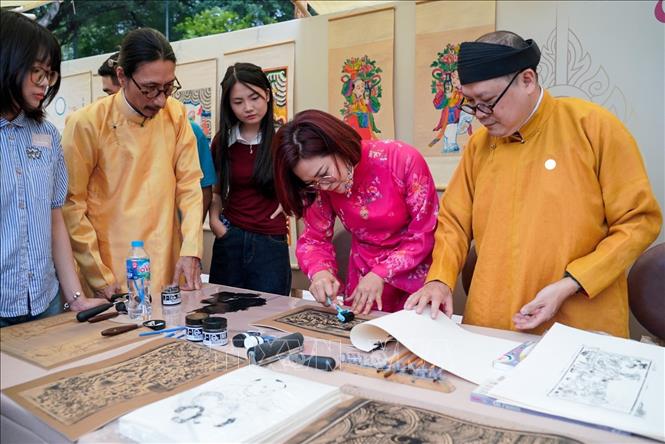 Người dân trải nghiệm in tranh dân gian tại chương trình. Ảnh: Khánh Hoà - TTXVN