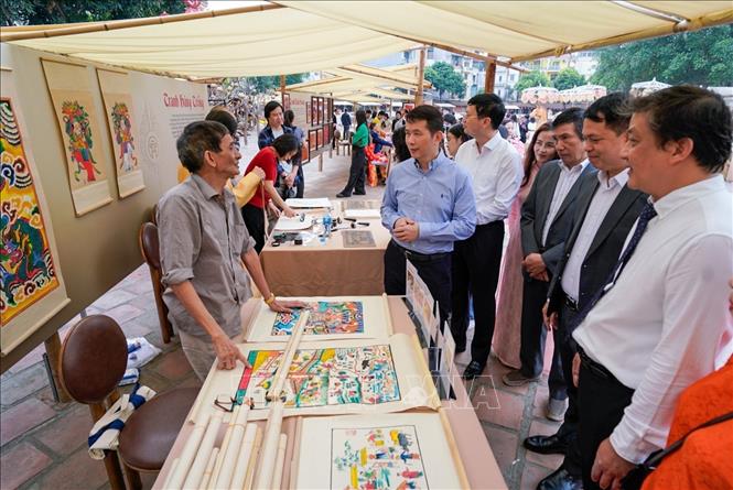 Các đại biểu tìm hiểu về dòng tranh dân gian Hàng Trống. Ảnh: Khánh Hoà - TTXVN