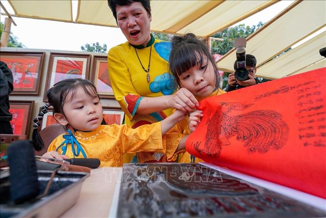 Các bạn nhỏ trải nghiệm in tranh dân gian Kim Hoàng. Ảnh: Khánh Hoà - TTXVN