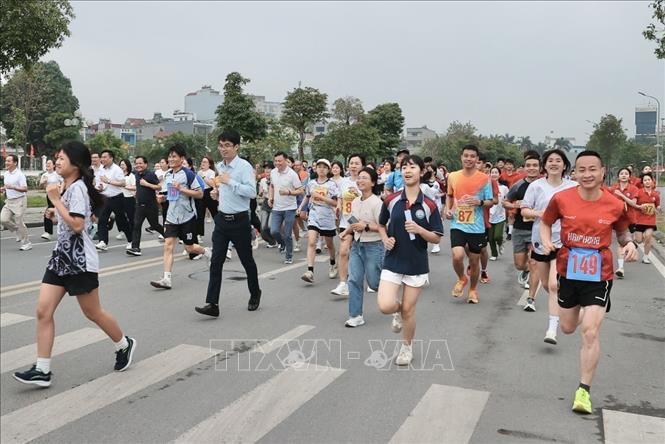 Đại biểu, VĐV tham gia chạy hưởng ứng. Ảnh: Minh Quyết - TTXVN