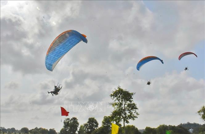 Các phi công dù lượn bay trình diễn trên bầu trời xã Tri Tôn, tỉnh An Giang. Ảnh: Công Mạo-TTXVN