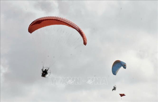 Các phi công dù lượn bay trình diễn trên bầu trời xã Tri Tôn, tỉnh An Giang. Ảnh: Công Mạo-TTXVN