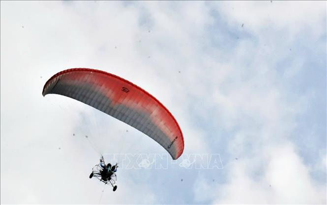 Các phi công dù lượn thể kiện kỹ năng điều khiển khiển dù từ đỉnh Phụng Hoàng Sơn hạ cánh tiếp đất vào tâm mục tiêu có bán kính 16cm tại sân đua bò Khu Thể thao - Du lịch Tà Pạ - Soài Check. Ảnh: Công Mạo-TTXVN
