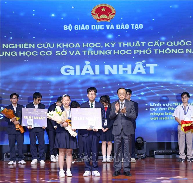 Thứ trưởng Thường trực Bộ Giáo dục và Đào tạo Phạm Ngọc Thưởng trao giải Nhất cho các học sinh đạt giải. Ảnh: Thanh Tùng - TTXVN 
