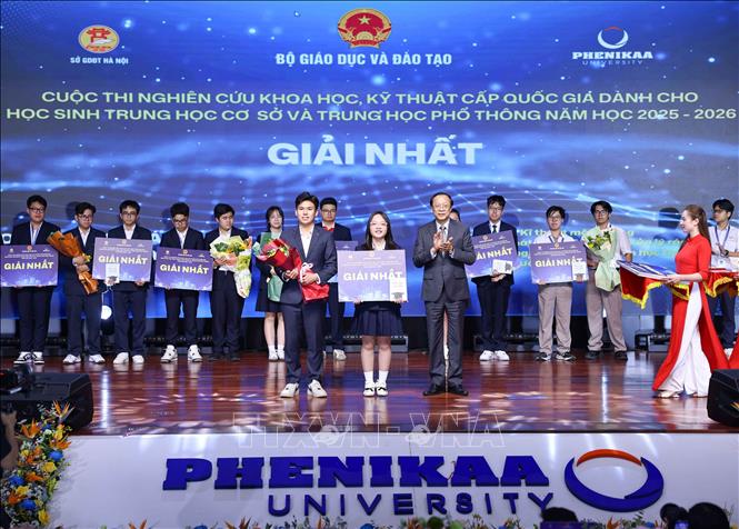 Thứ trưởng Thường trực Bộ Giáo dục và Đào tạo Phạm Ngọc Thưởng trao giải Nhất cho các học sinh đạt giải. Ảnh: Thanh Tùng - TTXVN 