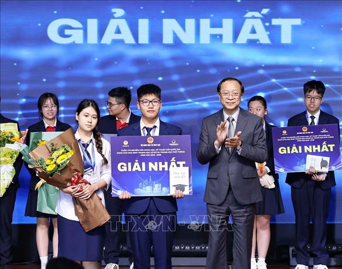 Thứ trưởng Thường trực Bộ Giáo dục và Đào tạo Phạm Ngọc Thưởng trao giải Nhất cho các học sinh đạt giải. Ảnh: Thanh Tùng - TTXVN 