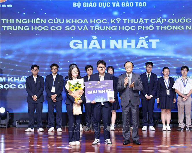 Thứ trưởng Thường trực Bộ Giáo dục và Đào tạo Phạm Ngọc Thưởng trao giải Nhất cho các học sinh đạt giải. Ảnh: Thanh Tùng - TTXVN 