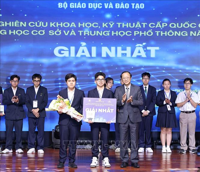 Thứ trưởng Thường trực Bộ Giáo dục và Đào tạo Phạm Ngọc Thưởng trao giải Nhất cho các học sinh đạt giải. Ảnh: Thanh Tùng - TTXVN 