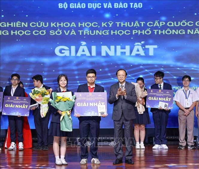 Thứ trưởng Thường trực Bộ Giáo dục và Đào tạo Phạm Ngọc Thưởng trao giải Nhất cho các học sinh đạt giải. Ảnh: Thanh Tùng - TTXVN 