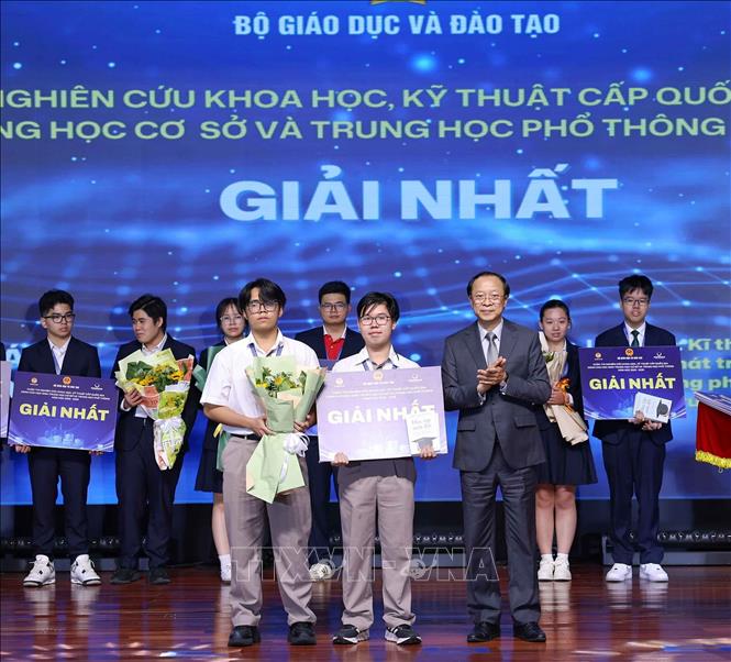 Thứ trưởng Thường trực Bộ Giáo dục và Đào tạo Phạm Ngọc Thưởng trao giải Nhất cho các học sinh đạt giải. Ảnh: Thanh Tùng - TTXVN 