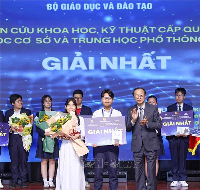 Thứ trưởng Thường trực Bộ Giáo dục và Đào tạo Phạm Ngọc Thưởng trao giải Nhất cho các học sinh đạt giải. Ảnh: Thanh Tùng - TTXVN 