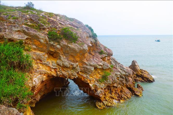 Nhìn từ trên cao, khu vực hang Mũi Trâu như một khuôn mặt người đang nhìn ra biển, cửa hang ngập trong nước khi thủy triều dâng cao. Ảnh: Xuân Tiến – TTXVN 