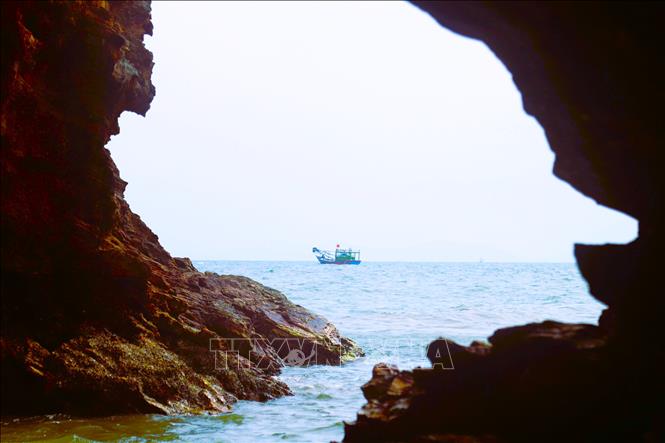 Tàu thuyền của ngư dân xã Quỳnh Phú (tỉnh Nghệ An) đi qua khu vực hang Mũi Trâu. Ảnh: Xuân Tiến – TTXVN