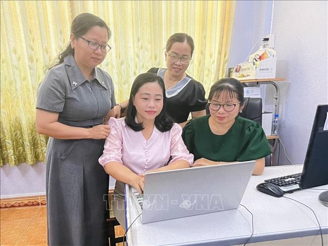 Chi bộ Hội Liên hiệp Phụ nữ tỉnh Đồng Tháp đang trực tiếp hướng dẫn các thành viên sử dụng công nghệ số. Ảnh: Hồng Nhung - TTXVN 
