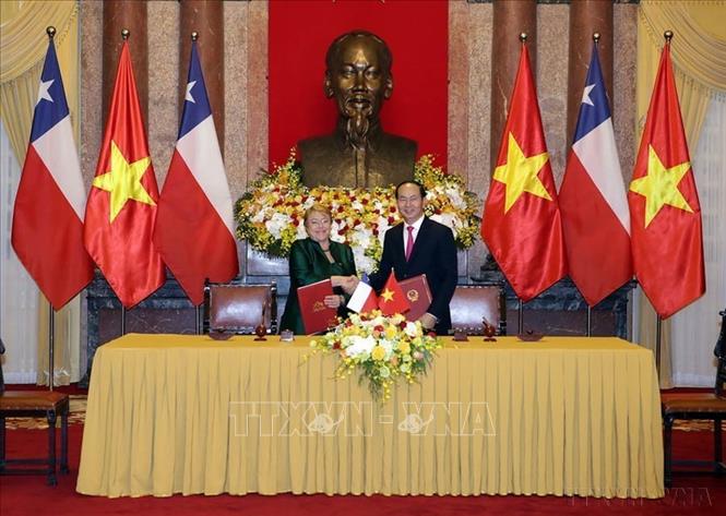 Chủ tịch nước Trần Đại Quang và Tổng thống Chile Michelle Bachelet trao bản ký kết văn kiện hợp tác giữa hai nước trong chuyến thăm cấp Nhà nước đến Việt Nam, ngày 9/11/2017. Ảnh: Nguyễn Dân – TTXVN