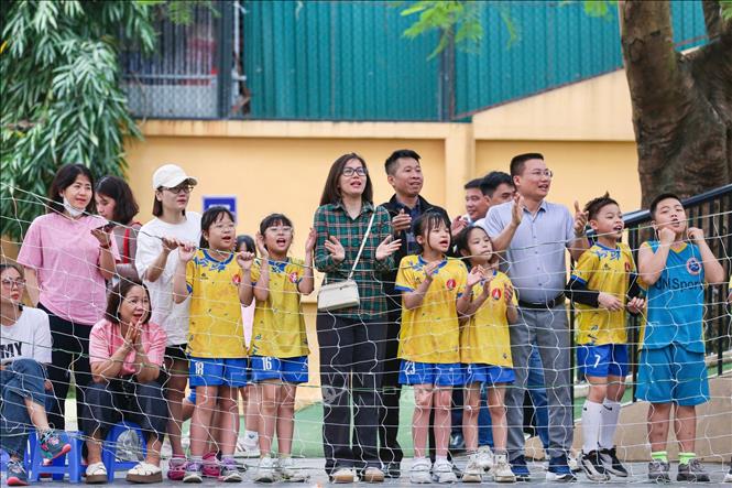 Các bạn nam lớp 5P4 nhiệt tình cổ vũ cho đội bóng rổ nữ của lớp mình thi đấu thật tốt. Ảnh: Hà Anh/TTXVN phát