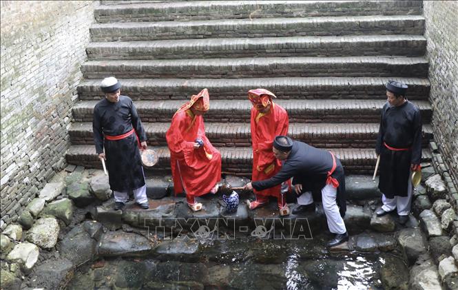 Các cụ cao tuổi lấy nước tại Đền cùng- Giếng ngọc rồi rước về Đền Vua Bà. Ảnh: Thanh Thương- TTXVN