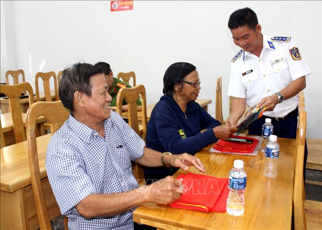 Chương trình tặng cờ Tổ quốc và phát tờ rơi tuyên truyền chống khai thác IUU cho ngư dân tại phiên tòa giả định. Ảnh: Hồng Hiếu- TTXVN