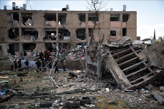 Lực lượng cứu hộ làm nhiệm vụ tại hiện trường một khu vực trúng tên lửa của Iran tại Dimona, Israel ngày 22/3/2026. Ảnh: THX/TTXVN