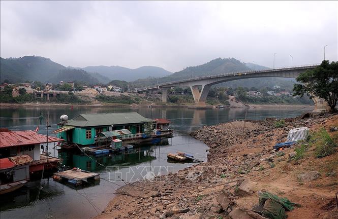 Nước hạ du sông Đà bị cạn, nhiều mỏm đất đá nhô cao khiến người dân làng chài di chuyển khó khăn. Ảnh: Thanh Hải - TTXVN  
