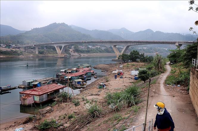 Nước hạ du sông Đà bị cạn, khiến người dân làng chài di chuyển lên bờ gặp khó khăn. Ảnh: Thanh Hải - TTXVN  