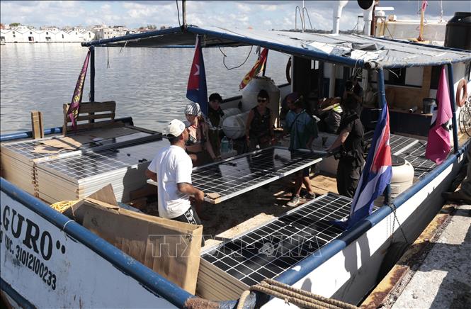 Bốc, dỡ các tấm pin năng lượng mặt trời trên tàu. Ảnh: Việt Hùng - PV TTXVN tại Cuba