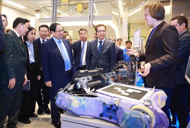 Thủ tướng Phạm Minh Chính xem sản phẩm nghiên cứu của sinh viên Đại học Nghiên cứu Công nghệ Quốc gia MISIS. Ảnh: Dương Giang - TTXVN