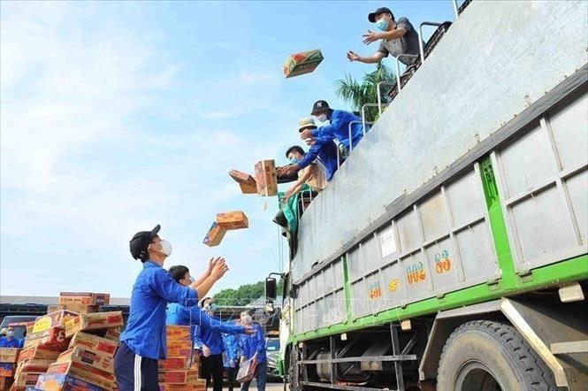 Đoàn viên thanh niên Hà Nội tiếp nhận nhu yếu phẩm và vận chuyển tới các khu vực phong tỏa, khu vực cách ly, những người lao động tự do, người khó khăn bị ảnh hưởng bởi dịch bệnh COVID-19 (9/2021). Ảnh: Minh Đức – TTXVN
