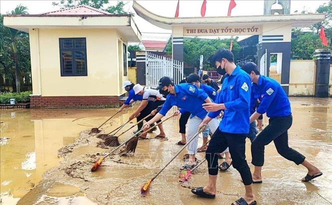 Đoàn viên thanh niên dọn dẹp vệ sinh, cào đẩy bùn non tại các điểm trường bị ảnh hưởng nặng trên địa bàn huyện Quảng Ninh, tỉnh Quảng Bình (11/2024). Ảnh: TTXVN phát