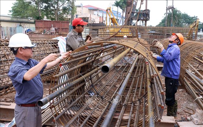 Công nhân thi công trụ sắt cọc khoan nhồi trên cạn phía đường Ngô Gia tự. Ảnh: Quốc Khánh - TTXVN