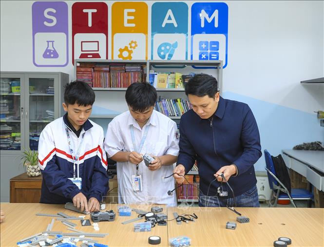 Giáo viên hướng dẫn học sinh trường Phổ thông Dân tộc Nội trú tỉnh Điện Biên lắp ghép thiết bị tại phòng Thư viện STEAM. Ảnh: Xuân Tư – TTXVN