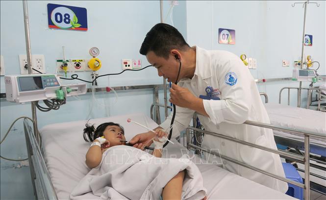 Bác sĩ Dư Tuấn Quy, Trưởng Khoa Nhiễm - Thần kinh, Bệnh viện Nhi đồng 1 Thành phố Hồ Chí Minh, khám cho bệnh nhi mắc tay chân miệng. Ảnh: Đinh Hằng - TTXVN