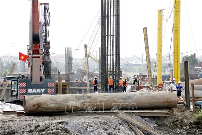 Công nhân tiến hành thi công trụ cầu vượt sông Ninh Cơ. Ảnh: Thái Thuần - TTXVN