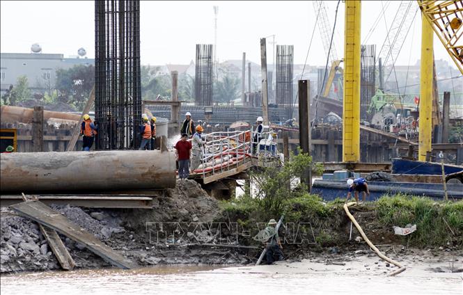 Công nhân tiến hành thi công trụ cầu vượt sông Ninh Cơ. Ảnh: Thái Thuần - TTXVN