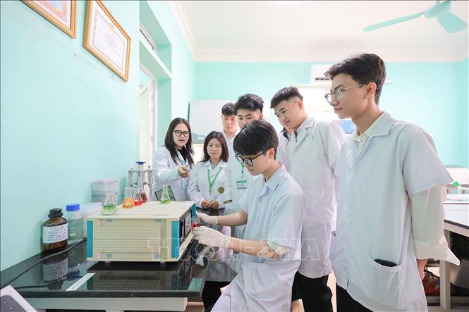 Sinh viên thực hành trên thiết bị phân tích mẫu nước để theo dõi và quản lý chất lượng môi trường nước thủy sản. Ảnh: Lê Đông - TTXVN
