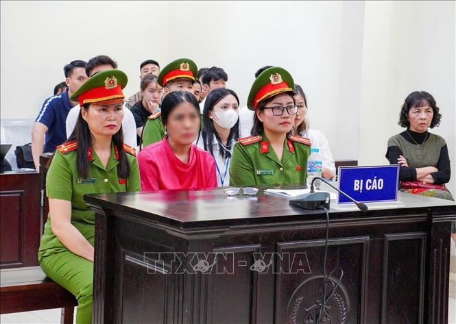 Bị cáo Nguyễn Thị Bình (áo hồng, giữa) tại phiên tòa. Ảnh: Kim Anh - TTXVN