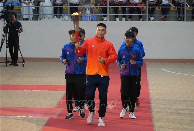 Các vận động viên tiêu biểu rước đuốc vào khán đài. Ảnh: Dư Toán – TTXVN