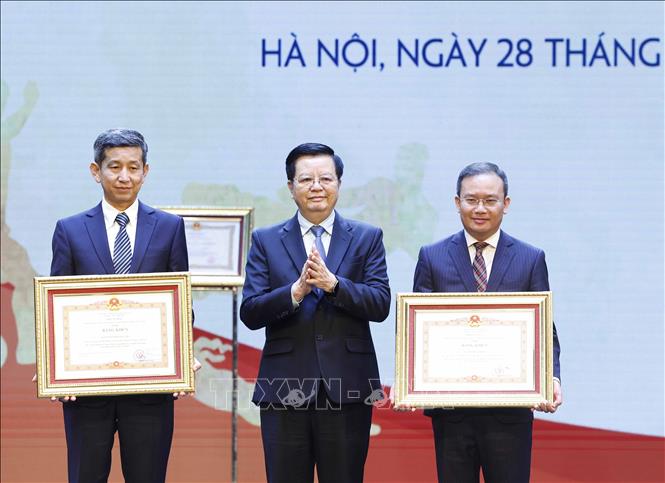Phó Thủ tướng Mai Văn Chính trao Bằng khen của Thủ tướng Chính phủ tặng các đồng chí: Nguyễn Danh Hoàng Việt (bên trái, Cục trưởng Cục Thể dục, Thể thao Việt Nam) và Nguyễn Hồng Minh (bên phải, Phó Cục trưởng Cục Thể dục, Thể thao Việt Nam). Ảnh: Thống Nhất – TTXVN