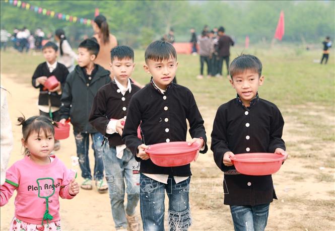 Các em thiếu nhi lấy nước từ dười suối về chuản bị cho phần nghi thức té nước vào đoàn rước nước. Ảnh: Quý Trung – TTXVN