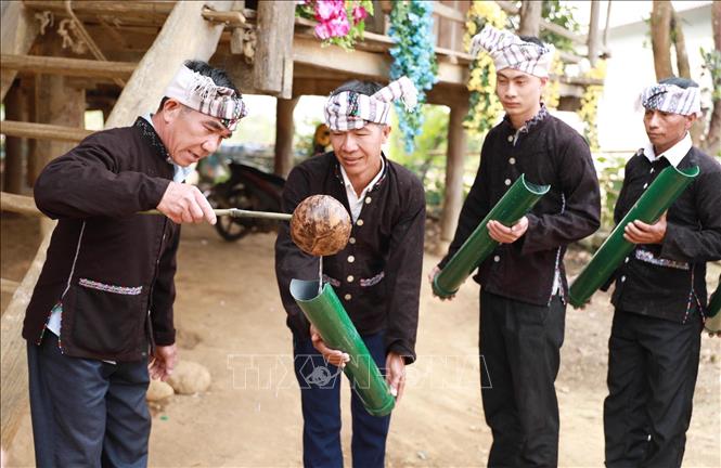 Sau khi nghe thấy lời gọi của chủ lễ, chủ nhà xuống nhà lấy nước trong chum cho người dân trong bản về làm lễ tại chùa cầu mong cho mưa thuận gió hòa, mùa màng tươi tốt. Ảnh: Quý Trung – TTXVN