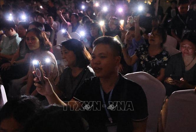 Điểm nhấn đặc biệt của Live Concert nằm ở phần kết chương trình, khi toàn bộ không gian Nhà Bát Giác đồng loạt tắt đèn hưởng ứng Giờ Trái Đất. Trong khoảnh khắc ấy, ánh sáng từ hàng nghìn chiếc điện thoại và nến hòa cùng giai điệu “Heal the World”, tạo nên một khung cảnh lung linh, giàu tính biểu tượng và đầy nhân văn. Ảnh: Minh Đức - TTXVN