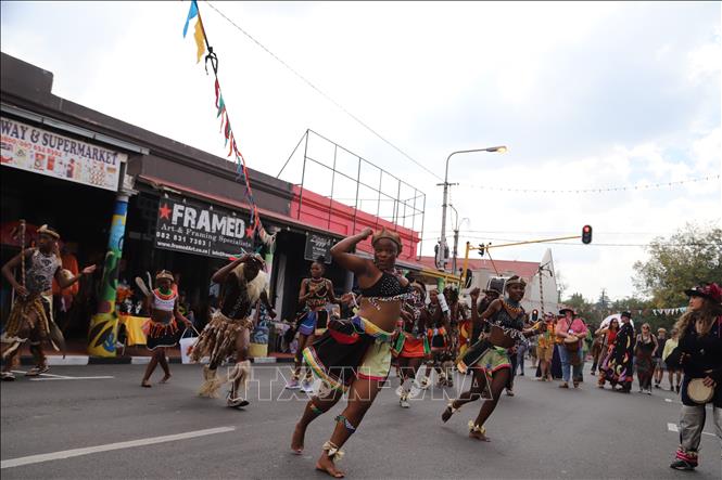 Các nghệ sĩ Zulu trong trang phục đính lông thú đặc trưng, vòng cổ hạt cườm lung linh, lông vũ lấp lánh và khiên truyền thống đã khiến cả con phố rung chuyển theo nhịp trống dồn dập và tiếng hát vang vọng. Ảnh: Hồng Minh - PV TTXVN tại Nam Phi