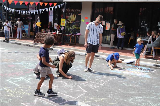 Ngay cả mặt đường cũng trở thành “tấm toan” để người lớn lẫn trẻ em thỏa sức vẽ vời, sáng tạo với phấn mầu. Ảnh: Hồng Minh - PV TTXVN tại Nam Phi
