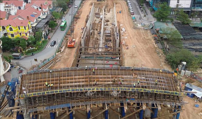 Trên công trường, công nhân và máy móc được huy động, thi công 