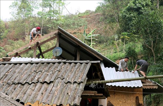 Các hộ dân xã Bắc Mê (Tuyên Quang) cùng các lực lượng giúp người dân lợp lại nhà bị lốc xoáy. Ảnh: Đức Thọ - TTXVN