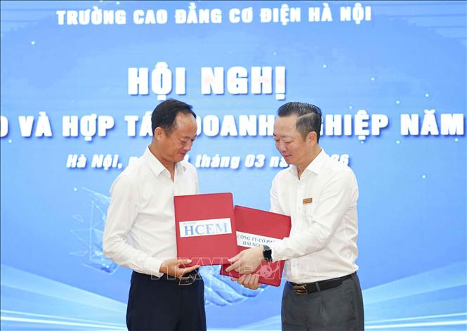 NGƯT, Tiến sĩ Đồng Văn Ngọc, Bí thư Đảng ủy - Hiệu trưởng HCME trao văn bản thỏa thuận hợp tác cùng các đối tác, doanh nghiệp. Ảnh: Thanh Tùng - TTXVN
