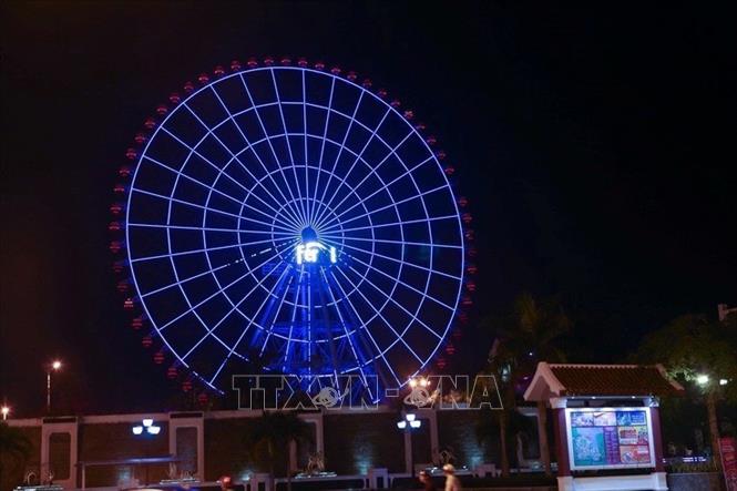 Tối 2/4/2019, hệ thống Vòng quay Mặt trời (Sun Wheel) tại thành phố Đà Nẵng được thắp sáng bằng ánh sáng đèn màu xanh, màu đại diện cho nhận biết về hội chứng tự kỷ. Ảnh: Trần Lê Lâm - TTXVN
