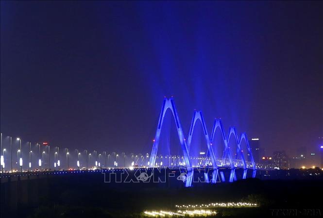 Tối 2/4/2019, hưởng ứng chiến dịch toàn cầu Thắp đèn xanh - Light it up blue, cầu Nhật Tân (Hà Nội) được chiếu sáng xanh, màu sắc đại diện cho sự nhận biết về hội chứng tự kỷ. Ảnh: Lâm Khánh - TTXVN