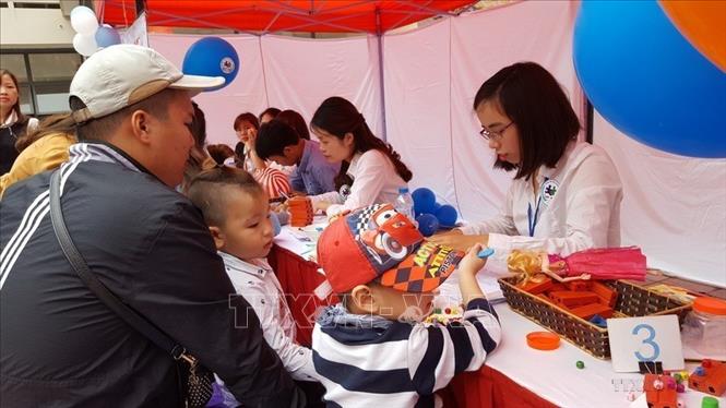 Khám và tư vấn sức khỏe cho trẻ bị tự kỷ trong Ngày hội “Vòng tay yêu thương”. Ảnh: Kim Anh - TTXVN