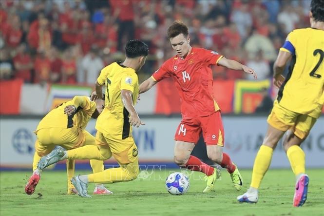 Hoàng Đức (14) vững chắc ở tuyến giữa, cùng với Quang Hải đảm trách nhiệm vụ đánh chặn và phát động tấn công. Ảnh: Minh Quyết - TTXVN